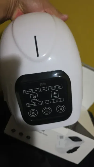 Knee massager held in hand by a verified buyer, control panel showing the heating and vibration settings